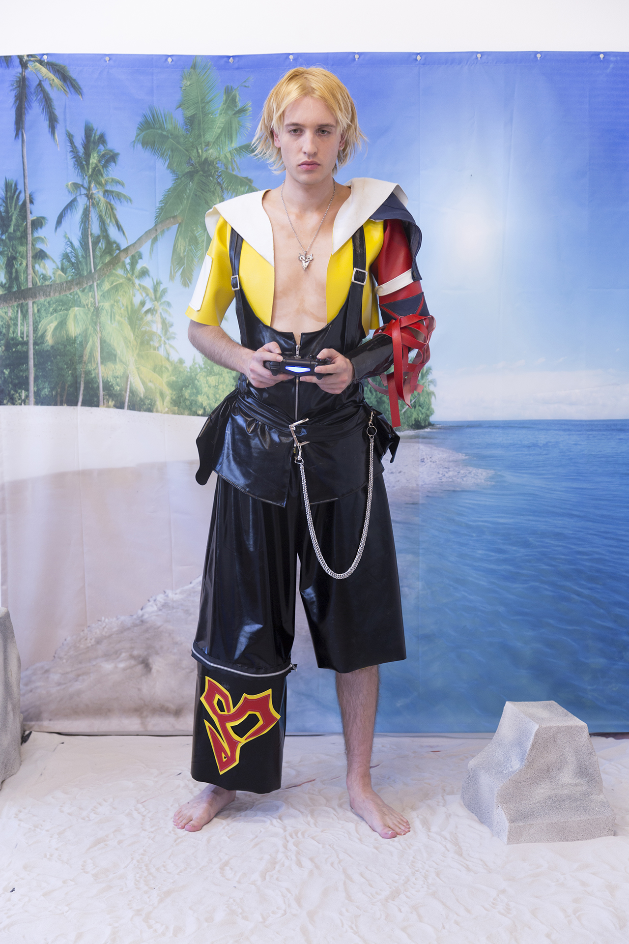 Detail of Jesse dressed in cosplay playing video games on an artificial beach set